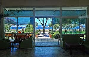 a restaurant with a view of a patio through a glass door at Dikelya Hotel in Dikili