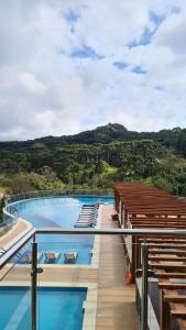a view of a swimming pool with mountains in the background at Apartamento no Golden Resort Laghetto in Gramado