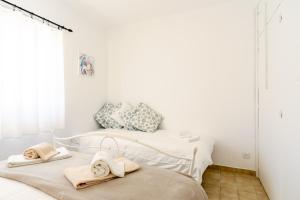two beds in a white room with towels on them at Vitamin Sea - Contemporary Beach Villa with heated pool in Altura