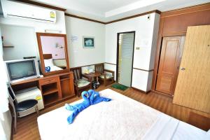 Krabi Grand Hotel في مينْغكرابي: غرفة نوم بسرير كبير وتلفزيون