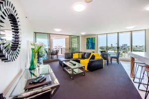 a living room with a couch and a table at Lanai Riverside Apartments in Mackay