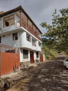 uma casa branca com uma cerca laranja e uma estrada em Puente de Gocta em Cocachimba