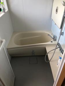 y baño pequeño con bañera y lavamanos. en STAY CHILL, en Mitsugoe