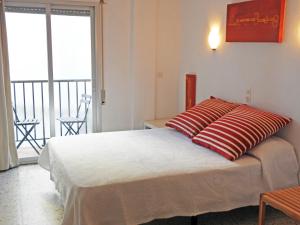 a bedroom with a large bed and a balcony at Pensió Vista Alegre in L'Escala