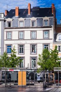 - un grand bâtiment blanc avec un panneau dans l'établissement The Originals Boutique, Hôtel Le Lion, Clermont-Ferrand, à Clermont-Ferrand