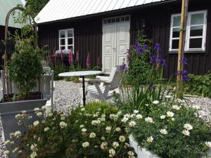 a garden with a bench and flowers in front of a house at Flickebäck in Förslöv +20 photos