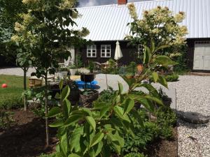 einen Garten mit zwei Bäumen und einem Gebäude in der Unterkunft Flickebäck in Förslöv