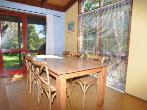 een eetkamer met een houten tafel en stoelen bij Beechwood Surf Side in Inverloch