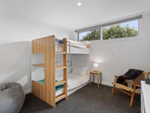 a bedroom with a bunk bed and a window at Normanby Coastal- walk to town & beach, free wifi & Netflix, all linen included. in Inverloch
