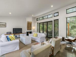 a living room with white furniture and a tv at HIDDEN ESCAPE FREE WIFI & FOXTEL SURFSIDE PET FRIENDLY (OUTSIDE ONLY) in Inverloch