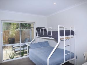 a bedroom with a bunk bed and a window at Sandpiper 3 Close To Beach And Town in Inverloch