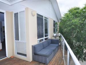 eine Veranda mit einem blauen Sofa auf dem Balkon in der Unterkunft Sandpiper 3 - Close to Town and Beach in Inverloch