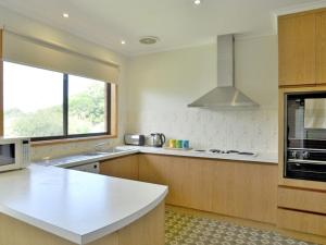 een keuken met een wit aanrecht en een raam bij Family Retreat on Anderson in Inverloch