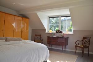 ein Schlafzimmer mit Bett, Schreibtisch und Fenster in der Unterkunft Cottage Marie-Henriette in Spa