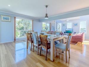 a dining room and living room with a table and chairs at THE LIGHTHOUSE - SURF SIDE in Inverloch