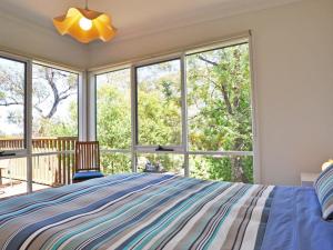 een slaapkamer met een bed en een groot raam bij Scarborough Serenity in Inverloch