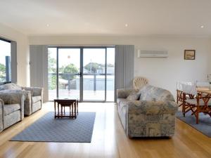 a living room with two couches and a table at Ridge End Inlet Side in Inverloch