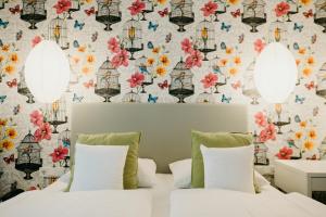 a bedroom with two beds and a floral wallpaper at Hotel Crystal in Saarbrücken +62 photos