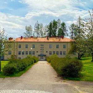 un gran edificio con una entrada que conduce a él en Ainola en Hämeenlinna