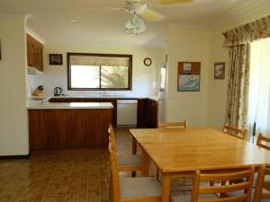 a kitchen and dining room with a wooden table and chairs at ANDERSON'S RETREAT - FREE WIFI - PET FRIENDLY (OUTSIDE ONLY) in Inverloch
