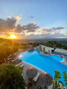 ein Resort mit einem großen Pool mit Sonnenschirmen in der Unterkunft Arolithos Traditional Village Hotel in Tílisos