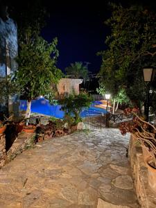 a night view of a swimming pool at night at Arolithos Traditional Village Hotel in Tílisos