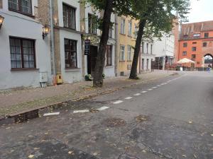 una calle urbana vacía con árboles y edificios en Dom Zachariasza Zappio, en Gdansk
