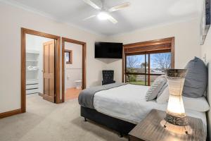 a bedroom with a bed and a table with a lamp at The Shamrock Luxury Retreat 