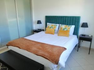 a bedroom with a large bed with a green headboard at iLOFT Loulé in Loulé