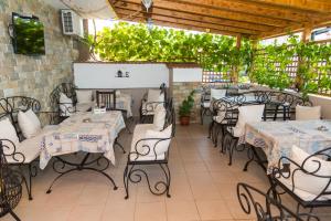 a patio with tables and chairs and plants at Rodos House in Pomorie