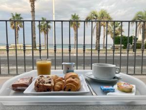a tray with a plate of pastries and a cup of orange juice at Hôtel Bel Azur in Six-Fours-les-Plages +30 photos
