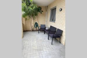 un patio con sillas, una mesa y un edificio en CENTRAL CLOSE SHOPS CITY AIRPORT WIFI NETFLIX PARK en Perth