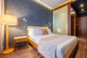 a bedroom with a bed and a lamp in a room at Chic Boutique Hotel Vlore in Vlorë