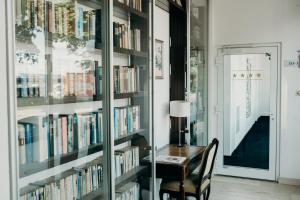 a room with a desk and bookshelves filled with books at Hotel Crystal in Saarbrücken