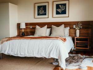 a bedroom with a large bed with a wooden headboard at Hearns Beachside Villa 8 in Port Fairy