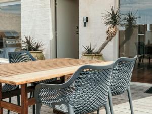 a wooden table and chairs with plants on a patio at Hearns Beachside Villa 8 in Port Fairy