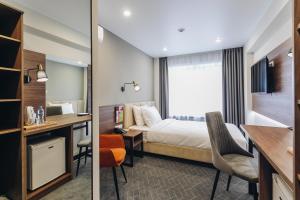Pokój hotelowy z łóżkiem i biurkiem w obiekcie Hotel Buryatia w Ułan Ude
