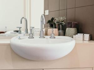 a bathroom with a white sink with two faucets at Hearns Beachside Villa 7 in Port Fairy
