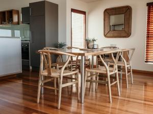 a kitchen with a wooden table and chairs at Hearns Beachside Villa 7 in Port Fairy