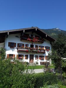 - un bâtiment blanc avec des fleurs sur les balcons dans l'établissement Huberhof, Mettenham, à Schleching