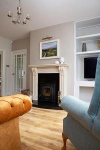 a living room with a fireplace and a couch at Patsy’s Corner Cottage in Enniskillen