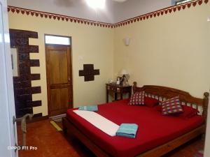 a bedroom with a bed and a dresser at Namaste Yoga Farm in Gokarna