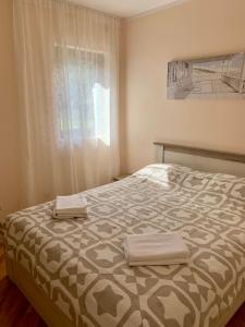 a bedroom with a bed with two towels on it at Lastochka.mne apartments in Baošići