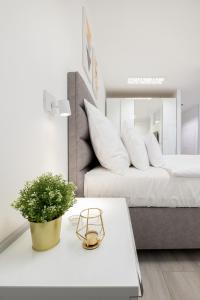 a living room with a bed and a table with a plant at Divat Apartments - Central Smart Homes in Győr