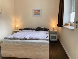 a bed with a wooden frame in a bedroom at Zum Eulennest in Rantrum