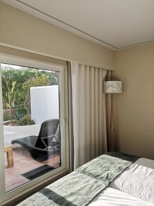 a bedroom with a bed and a window with a chair at Victory Village 16F in Quinta do Lago