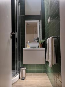 La salle de bains est pourvue d'un lavabo et de carrelage vert. dans l'établissement Victory Village 16F, à Quinta do Lago