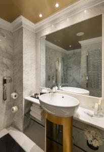 a bathroom with a sink and a tub and a mirror at The Excelsior - Small Luxury Hotels of the World in Thessaloniki