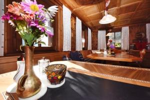 a vase of flowers sitting on a table with a bowl at Haus Saler in Gaschurn