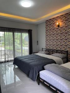 1 Schlafzimmer mit 2 Betten und einem großen Fenster in der Unterkunft Re-Live Resort in Ban Bang Phra